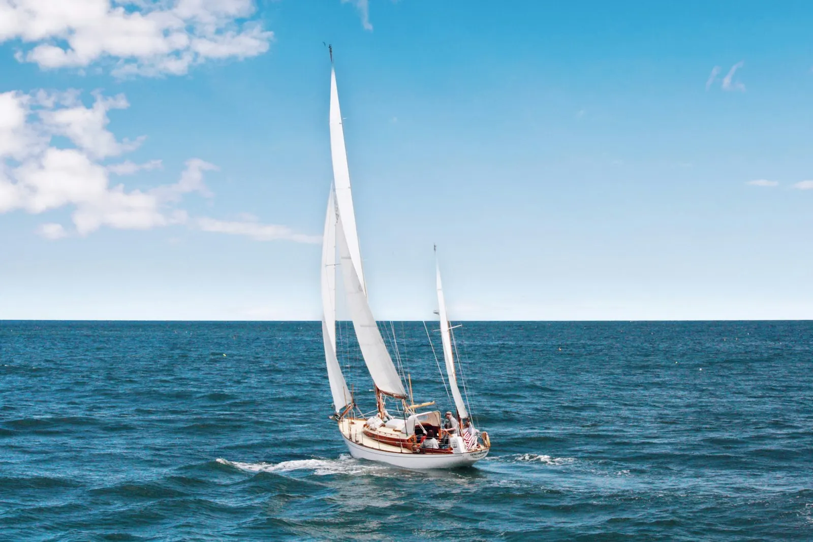 Sailboat under full sail on open Puget Sound water on a clear day