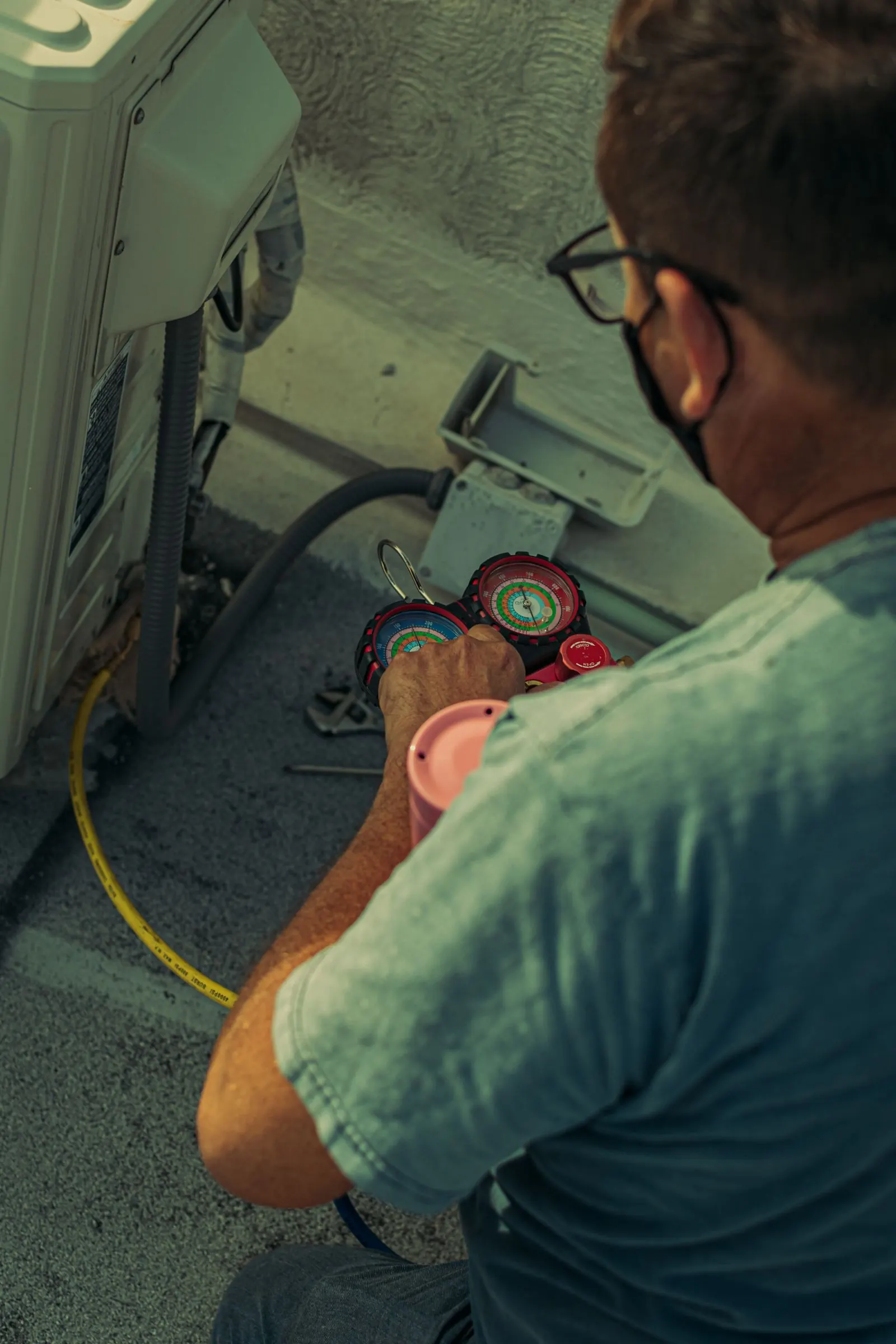 Technician verifying refrigerant charge on a newly installed heat pump outdoor unit