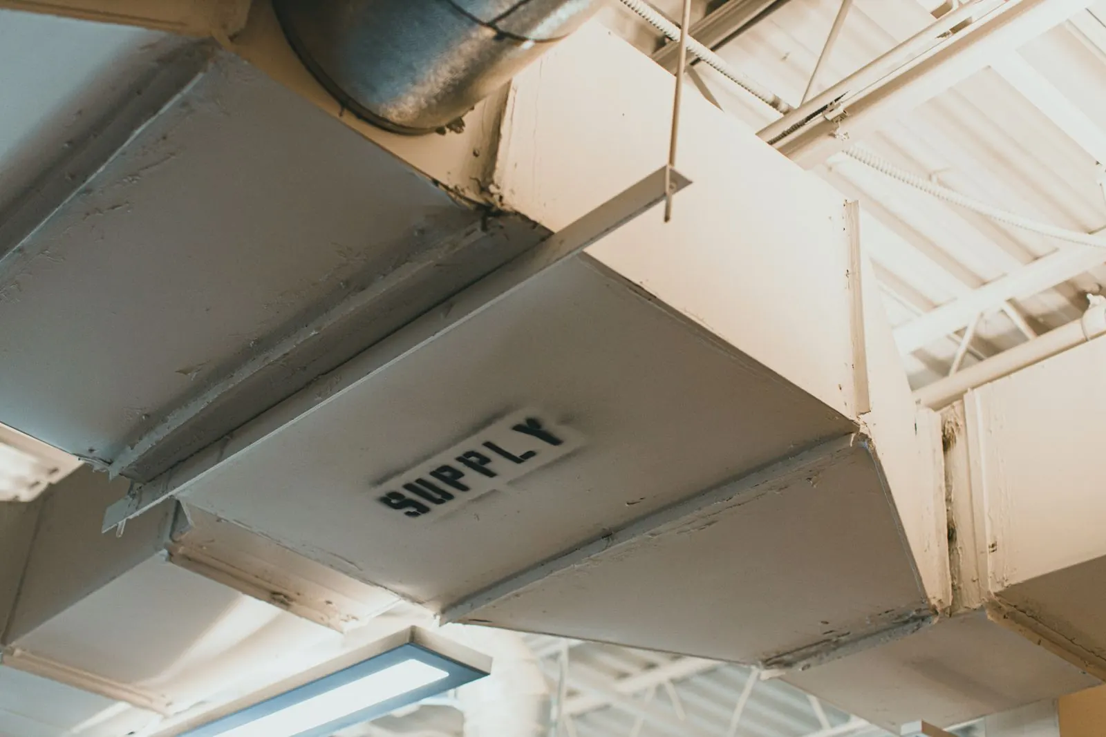 Labeled supply duct trunk installed in a commercial ceiling